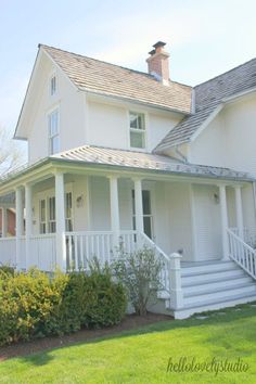 a large white house with a porch and stairs