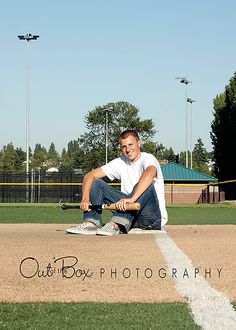 a man sitting on top of a baseball field