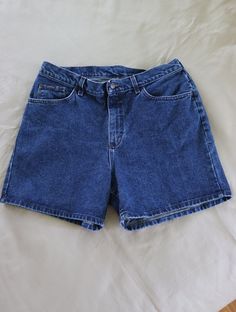 High-waisted / high-rise jean shorts by Lee Riders from the 1980s or 1990s.  100% Cotton and SO much more flattering than low-cut stretchy jeans!!  Button and zipper closure.  Size tag is unreadable - 18" waist measured flat (36 inches total); hips measure 23 inches flat (46 inches total); 12" from waist to crotch seam in front; 17" from waist to crotch seam in back; 5" inseam. Clean (freshly laundered and line dried), no stains, no holes. Measured flat, so the actual fit may vary somewhat. Measure a similar garment that fits you in the same manner for comparison. Visit my shop for more vintage clothing, fabric, fabric panels, quilt blocks and quilt tops, vintage patterns, needlework and kits, original handmade creations and more - https://www.etsy.com/shop/VirgieMae Lee24 90s Inspired Denim Shorts, Vintage Denim Blue High-waisted Shorts, Vintage High-waisted Dark Wash Jean Shorts, 90s Inspired Denim Jean Shorts, 90s Style Medium Wash High-waisted Jean Shorts, Vintage Dark Wash Jean Shorts For Summer, 90s Style Denim Blue Jean Shorts, 90s Denim Blue Jean Shorts, Retro Denim Blue Jean Shorts