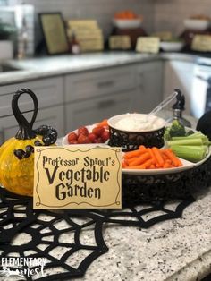 a sign that is sitting on a counter near some vegetables and carrots in bowls