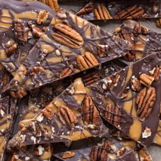 there are many pieces of chocolate and pecans on top of each other with nuts