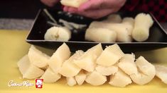 someone is cutting up pieces of food on a yellow tablecloth with a black plate