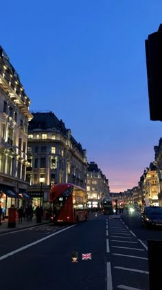 a city street at night with cars and buses