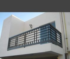 a white building with a black balcony and balconies