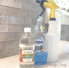 two bottles of cleaning products sitting on top of a counter