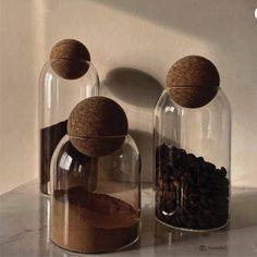 two glass jars with sand and coffee beans in them