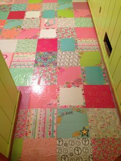 a colorful patchwork floor is shown in this photo, with yellow doors and green cupboards