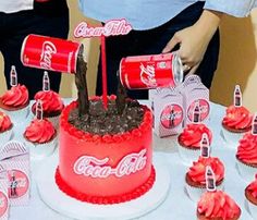 coca - cola cake and cupcakes on a table with two people pouring coke cans