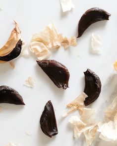 some pieces of chocolate are on a white surface with crinkled paper around them