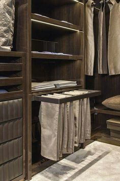 an organized closet with clothes hanging on shelves