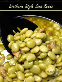 a spoon full of green beans sitting on top of a white tablecloth with the words southern style lima beans