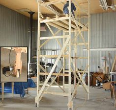 a man is standing on a scaffold in an industrial building