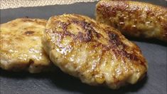 three pieces of meat sitting on top of a black plate