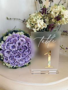 the table numbers are placed next to a bouquet of flowers