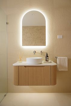 a bathroom with a round mirror above the sink