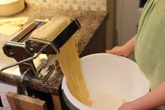 a person is holding a bowl with pasta in it and the noodles are being cooked