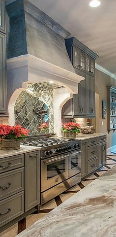 a large kitchen with gray cabinets and marble counter tops