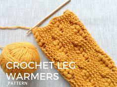 an orange crochet leg warmer next to a ball of yarn and knitting needles