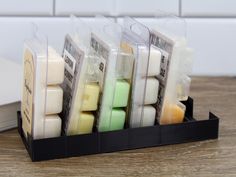 several different types of soaps sitting in a holder on a table next to an open book