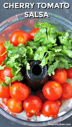 cherry tomatoes and parsley in a blender with text overlay reading cherry tomato salsa