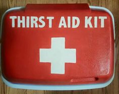 a red first aid kit sitting on top of a wooden table next to a white cross