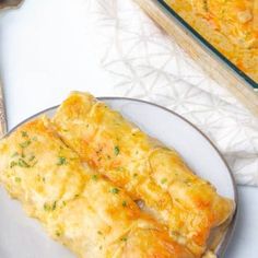 two slices of cheesy bread on a plate next to a casserole dish