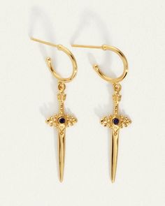 In ancient cultural ceremonies, the sword was a symbol of protection and bravery, representing courage when we need to call upon it most.  
 The Themis Earring, in polished 18k Gold Vermeil, features a sword elegantly suspended from a hoop and adorned by a Black Sapphire. The Themis Earrings hold the passion of a dagger piercing through the wall of fear holding us back from realising our full potential. Byron Bay Australia, Black Sapphire, Byron Bay, Full Potential, Earrings Gold, Gold Vermeil, Gold Earrings, The Sun, Temple