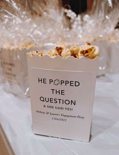 popcorn bags filled with popcorn sitting on top of a white tablecloth covered table cloth