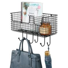 a bag and purse hanging from hooks next to each other on a rack with two umbrellas