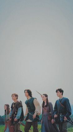 a group of people standing next to each other on top of a lush green field