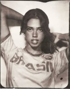 an old black and white photo of a woman with long hair wearing a chicago shirt