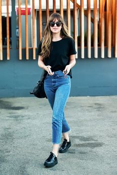 a woman in black shirt and jeans walking