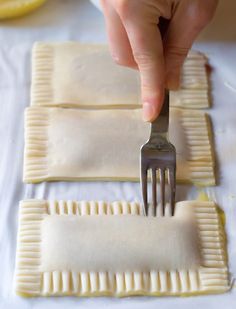 a person holding a fork over some ravioli on top of a white table cloth