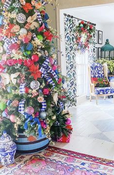 a decorated christmas tree in the middle of a living room with blue and white furniture