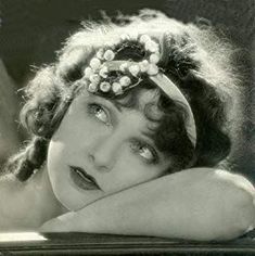 an old black and white photo of a woman with her head resting on her arm