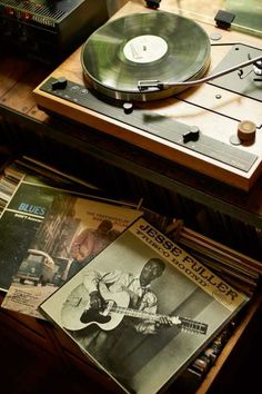 an old record player sitting on top of a wooden table next to other music equipment