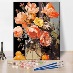 an art work with flowers in a vase and paintbrushes on the table next to it