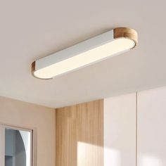 an overhead light in a room with wooden paneling and white cupboards on the wall