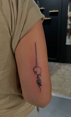 a woman with a tattoo on her arm holding a knife in one hand and an arrow in the other