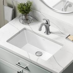 a white bathroom sink sitting under a mirror