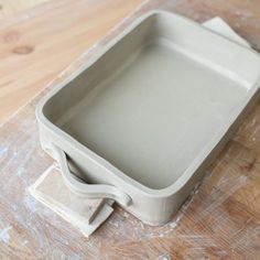 a white square container sitting on top of a wooden table