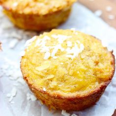 two coconut muffins sitting on top of white paper