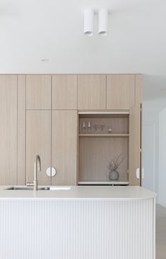 an empty kitchen with white cabinets and counter tops