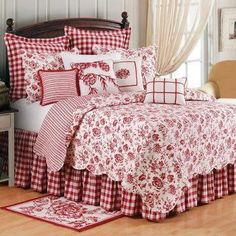 a bed with red and white bedspreads in a room