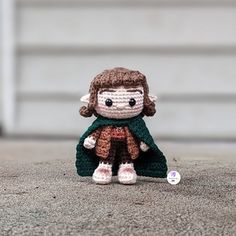 a small crocheted doll sitting on the ground