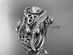 a wedding ring set with an intricate flower and vine design on the side, surrounded by diamonds