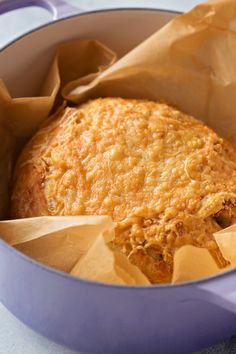 a casserole in a blue pot with brown paper on the side and napkins wrapped around it