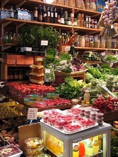 a store filled with lots of fresh fruits and vegetables next to shelves full of condiments