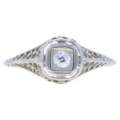 Size: 6 Sizing Fee: Up 2 sizes for $35 or Down 1 size for $35 Era: Art Deco Date: 1920s - 1930s Metal Content: 18k White Gold Stone Information Natural Diamond Carat(s): .10ct Cut: European Color: G Clarity: VS2 Total Carats: .10ct Style: Solitaire Features: Floral Filigree & Milgrain Detailing Measurements Face Height (north to south): 5/16" (7.8mm) Rise Above Finger: 1/4" (5.6mm) Weight: 1.5 Grams Stamps: 18k Condition: Pre-Owned Professionally cleaned, polished, and tested to guarantee metal Floral Filigree, La Face, Jewelry Rings Engagement, Diamond Art, Solitaire Engagement Ring, White Gold Diamonds, Ring Verlobung, Natural Diamonds, Metallica