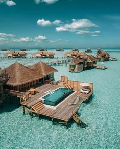 the water is crystal blue and clear with some huts on it that look like they are floating in the ocean